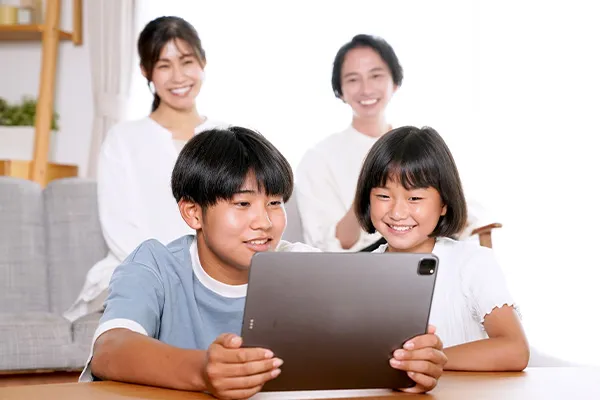 タブレットを囲んで一緒に学ぶ家族
