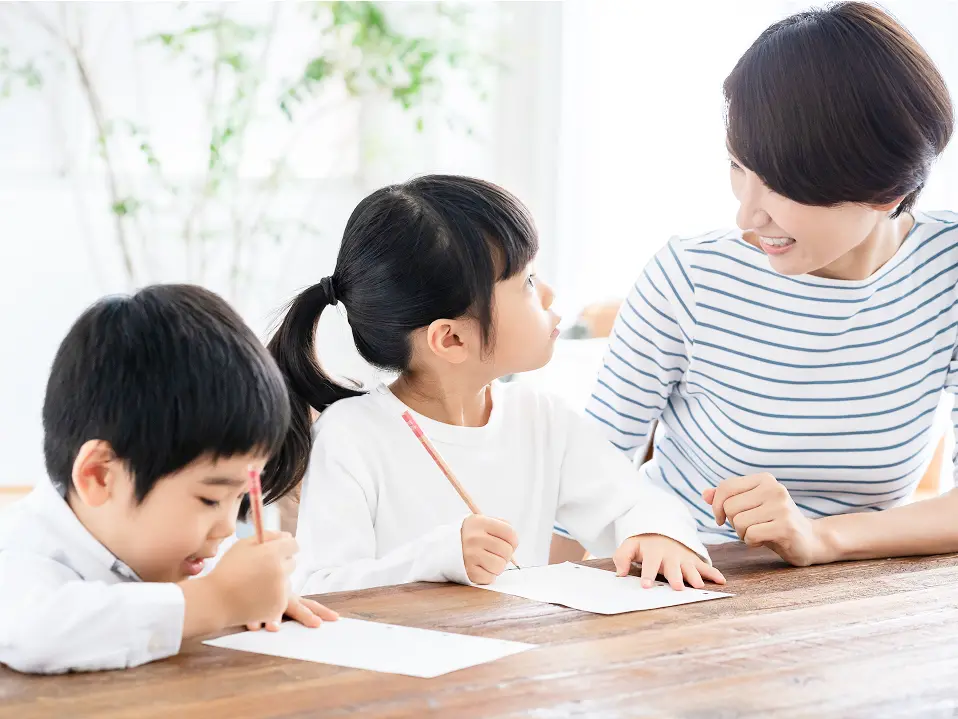 複数の子どもが家庭でプリント学習に取り組んでいる様子