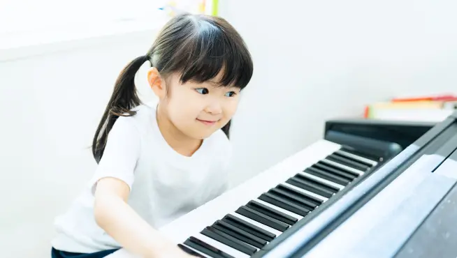 自宅でピアノを弾きながらオンライン体験レッスンを受ける様子