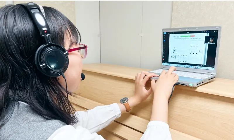 ヘッドセットをつけた講師が、パソコンの画面を見て操作している様子