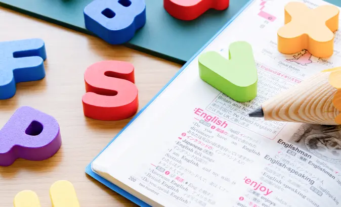 英語のノートとアルファベットブロックの画像