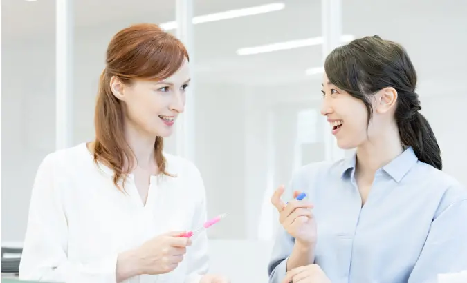 楽しそうに英会話をしている2人の女性の写真
