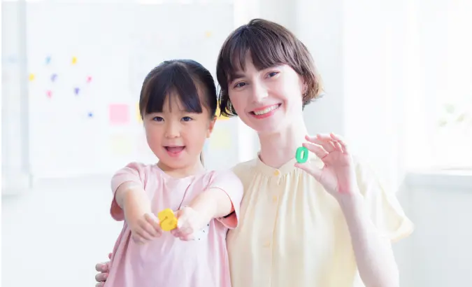 子どもと寄り添って笑顔を見せる女性の写真